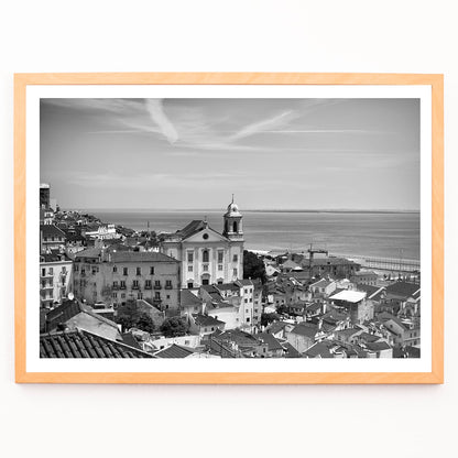 Black and white landscape poster of Alfama Lisbon Old City with traditional buildings and Tagus River by artist Alfama Lisbon, framed and displayed in modern living room decor