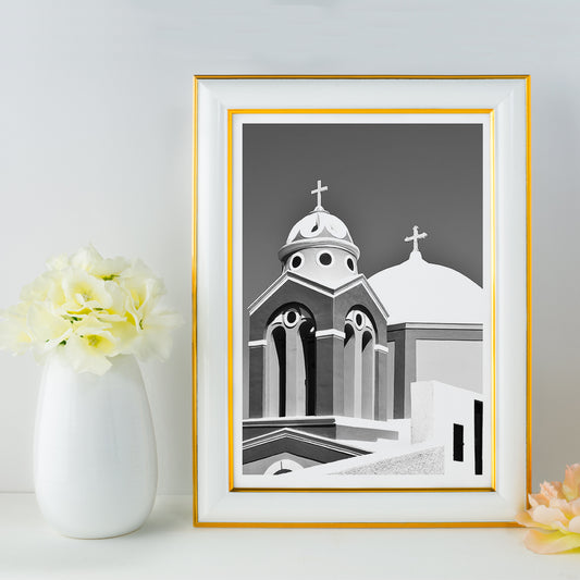 Black and white artwork of a traditional church dome and cross in Santorini Greece by artist Santorini Greece poster featuring classic architecture against a clear sky, framed and displayed in home decor