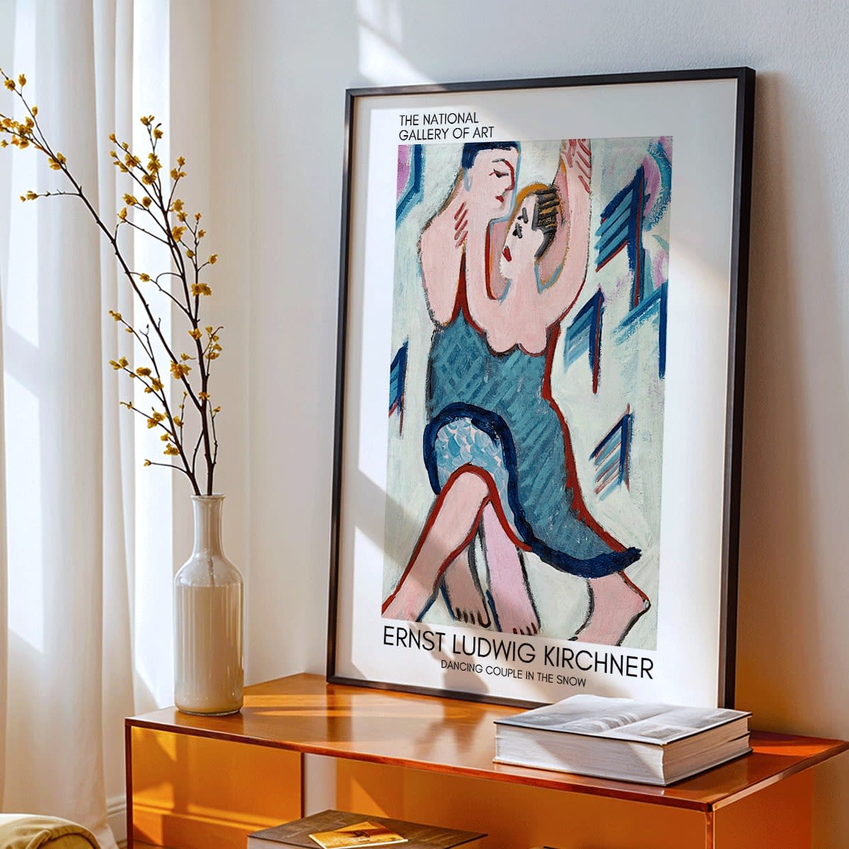 Dancing Couple in the Snow by Ernst Ludwig Kirchner vibrant expressive painting of a couple embracing and dancing in a snowy scene, framed and displayed in modern living room decor