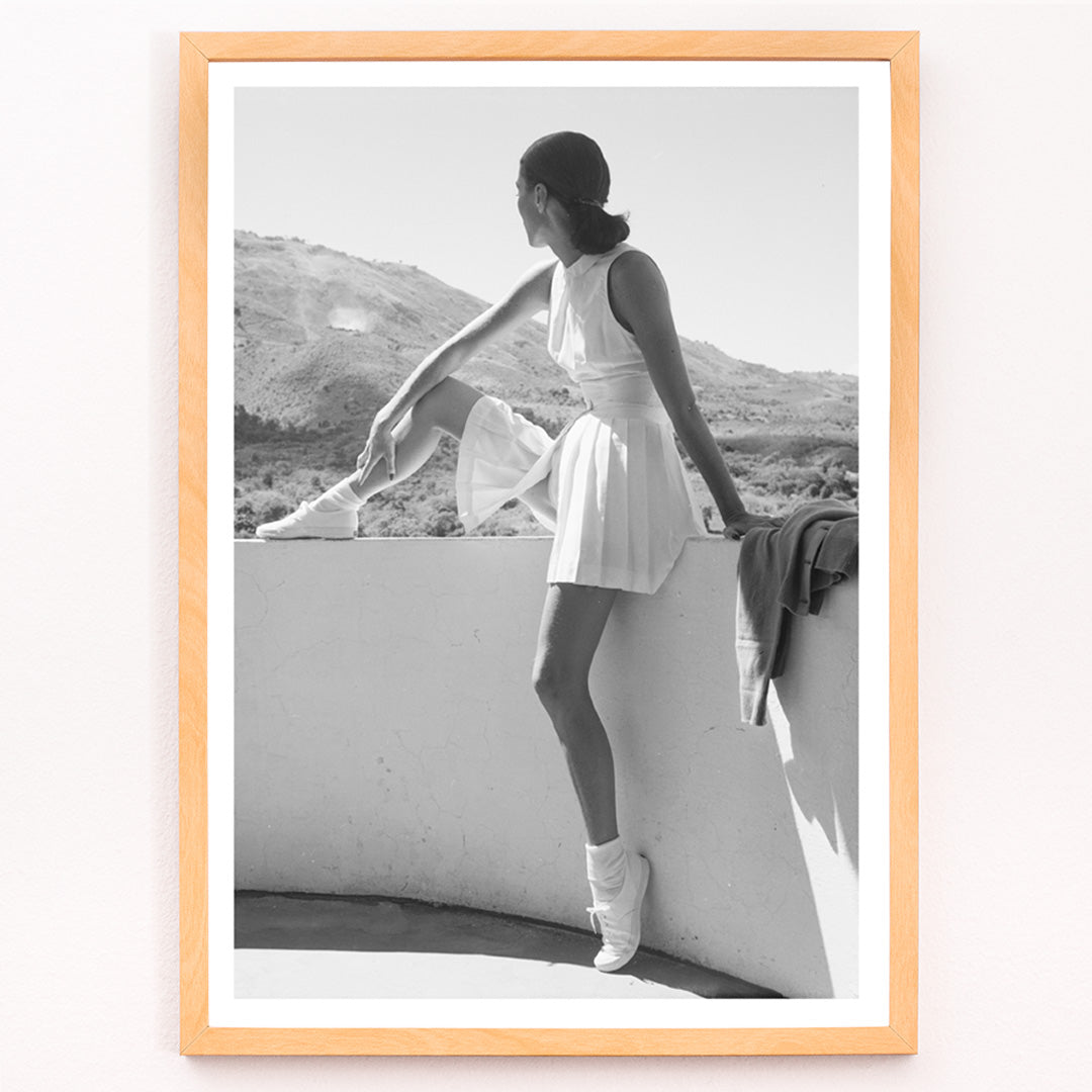 Closeup detail of Fashion model in tennis outfit seated on wall looking at mountains by Toni Frissell poster artwork