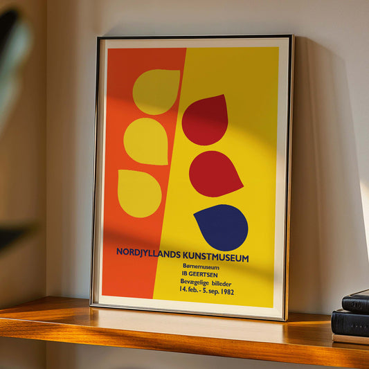 Exhibition poster by Ib Geertsen with colorful geometric shapes in yellow red and blue on an orange and yellow background, framed and displayed in home decor