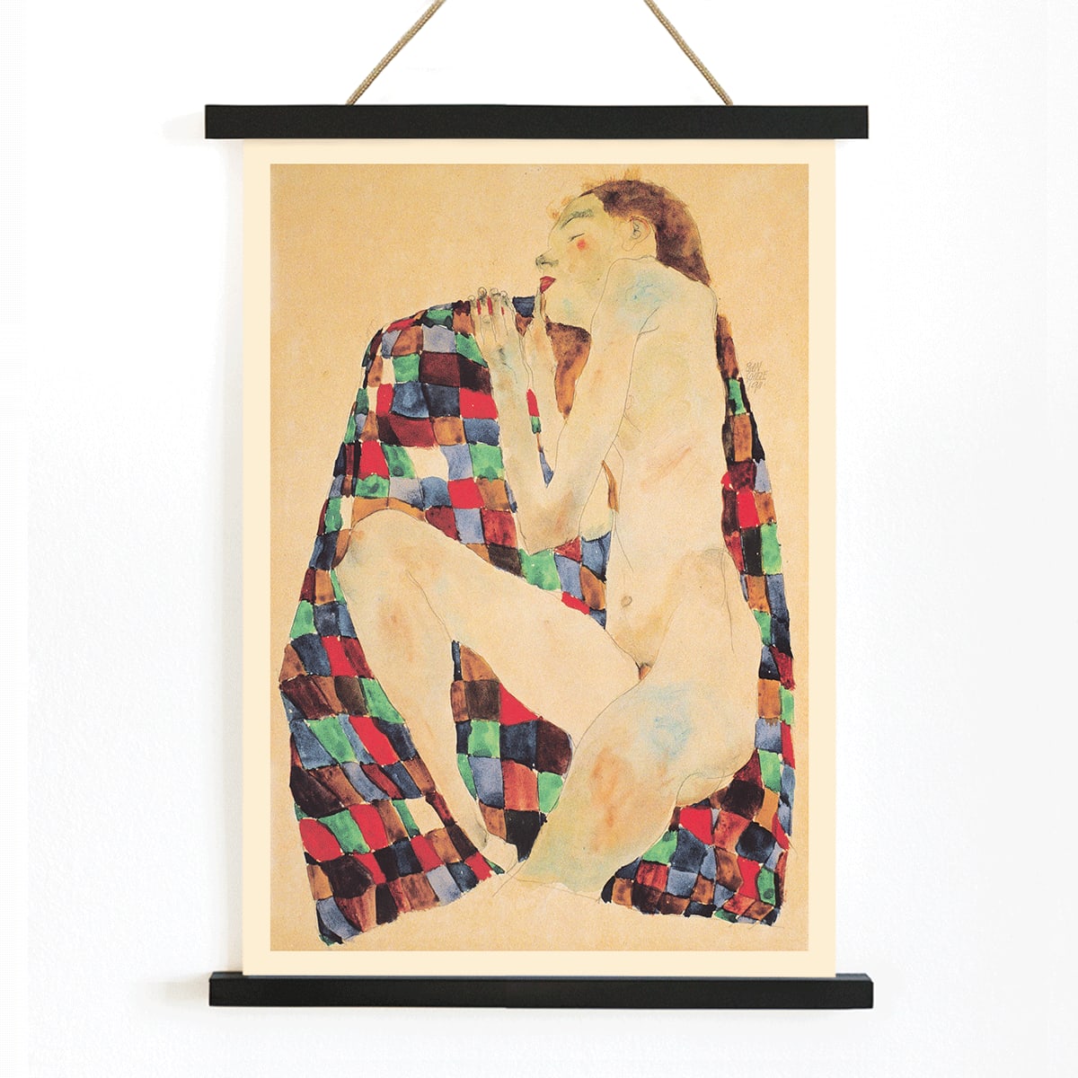 Female Nude on Checkered Cloth by Egon Schiele showing a nude woman sitting on a colorful patterned fabric poster, with wooden magnetic frame on white background