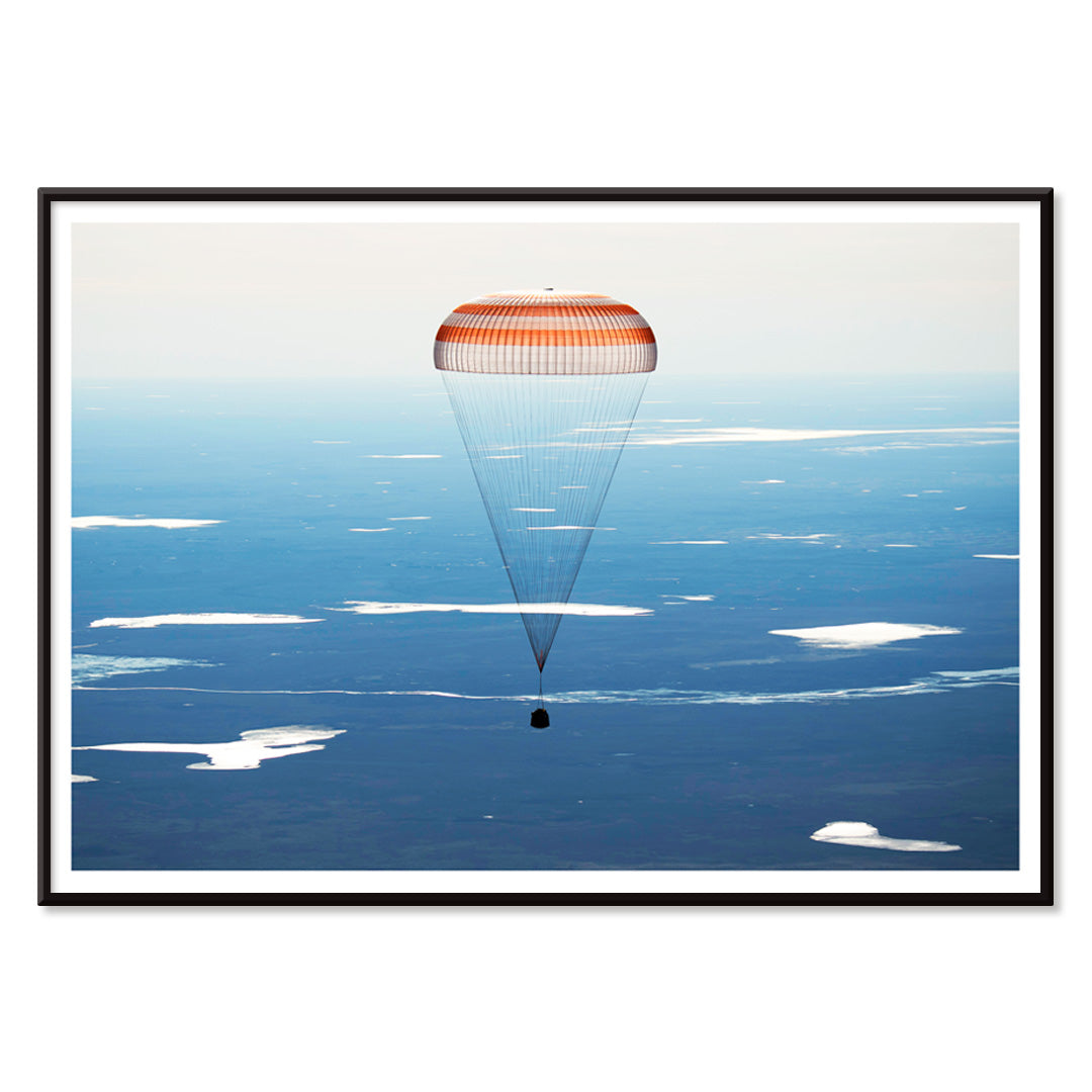 Soyuz MS-02 spacecraft descending with parachute over Kazakhstan NASA poster artwork showing landing, with black aluminium frame on white background