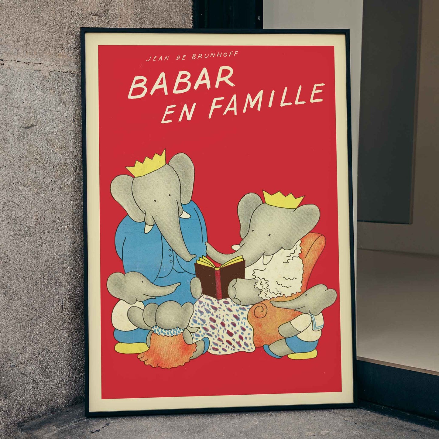 Elephant family illustration and poster from Babar en famille by Jean de Brunhoff with red background and family reading theme, framed and displayed in home decor
