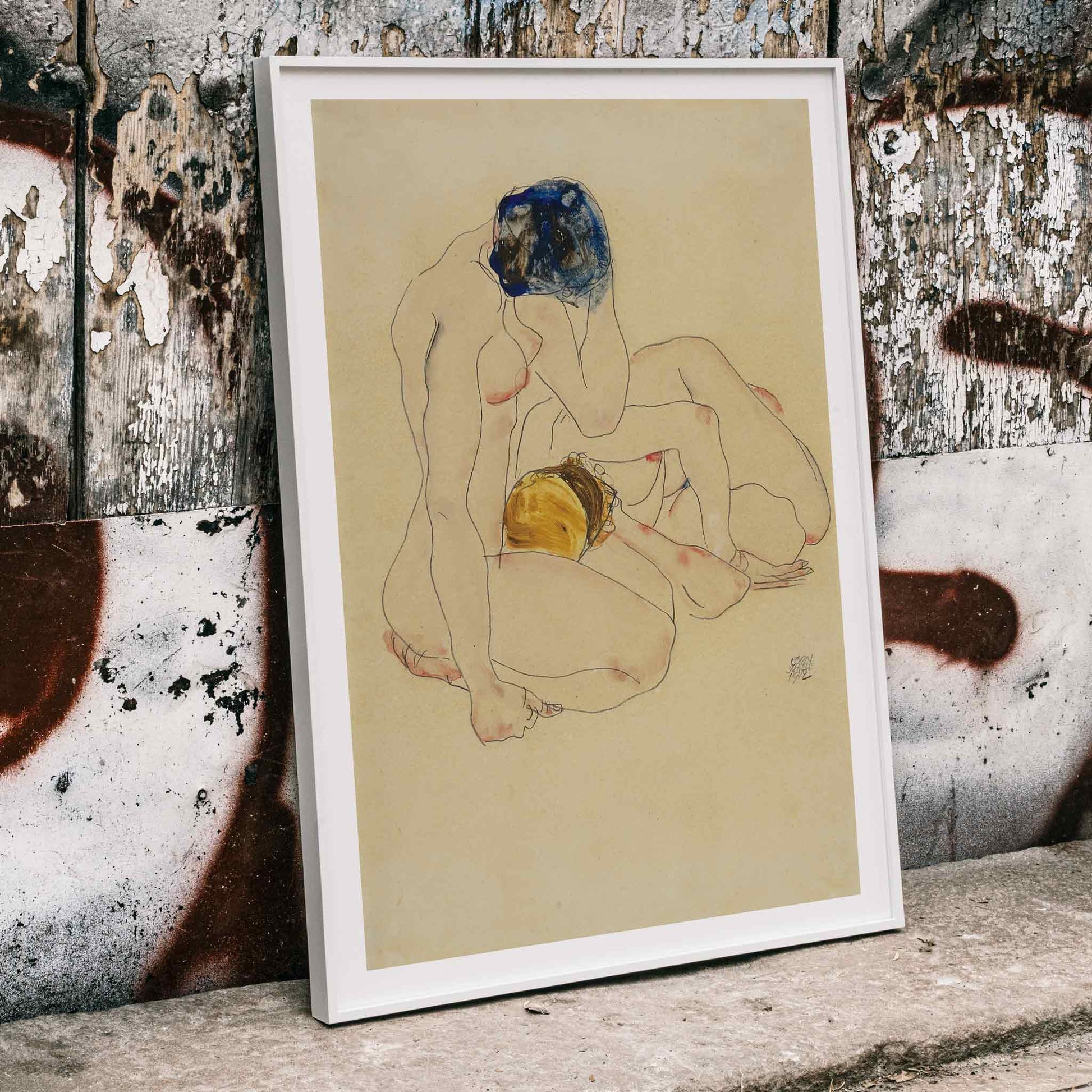 Two Friends by Egon Schiele poster featuring two nude figures in an intimate seated pose with expressive linework artwork, framed and displayed in home decor