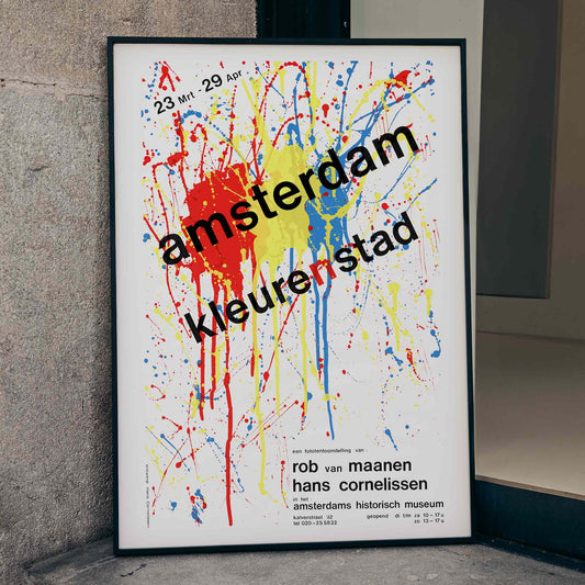 Amsterdam Color City vibrant abstract splatter artwork poster by Hans Cornelissen featuring bold text Amsterdam kleuren stad over colorful background, framed and displayed in home decor