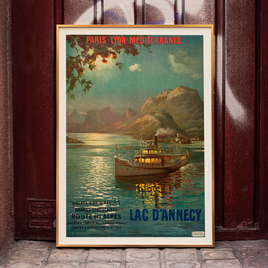 Poster of Lac d Annecy by Francois Charles Cachoud showing a boat on a serene lake with mountains and a glowing evening sky, framed and displayed in home decor