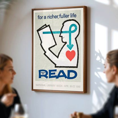 Poster with a stylized person reading a book and heart with bold text for a richer fuller life wake up and read by National Library, framed and displayed in modern living room decor