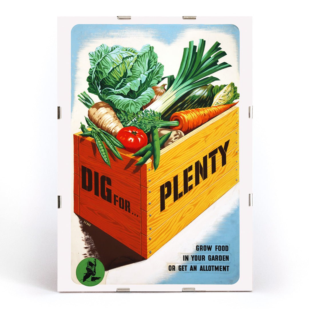 Vintage poster of a crate of fresh garden vegetables with text Dig for Plenty promoting self-sufficiency artwork by Mary Le Bon, framed and displayed in modern living room decor