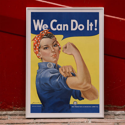 We Can Do It poster by J Howard Miller with determined woman flexing arm in blue and yellow wartime style, framed and displayed in home decor