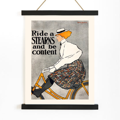Vintage poster of a woman riding a bicycle with the text Ride a Stearns and be content by Edward Penfield artwork, with wooden magnetic frame on white background