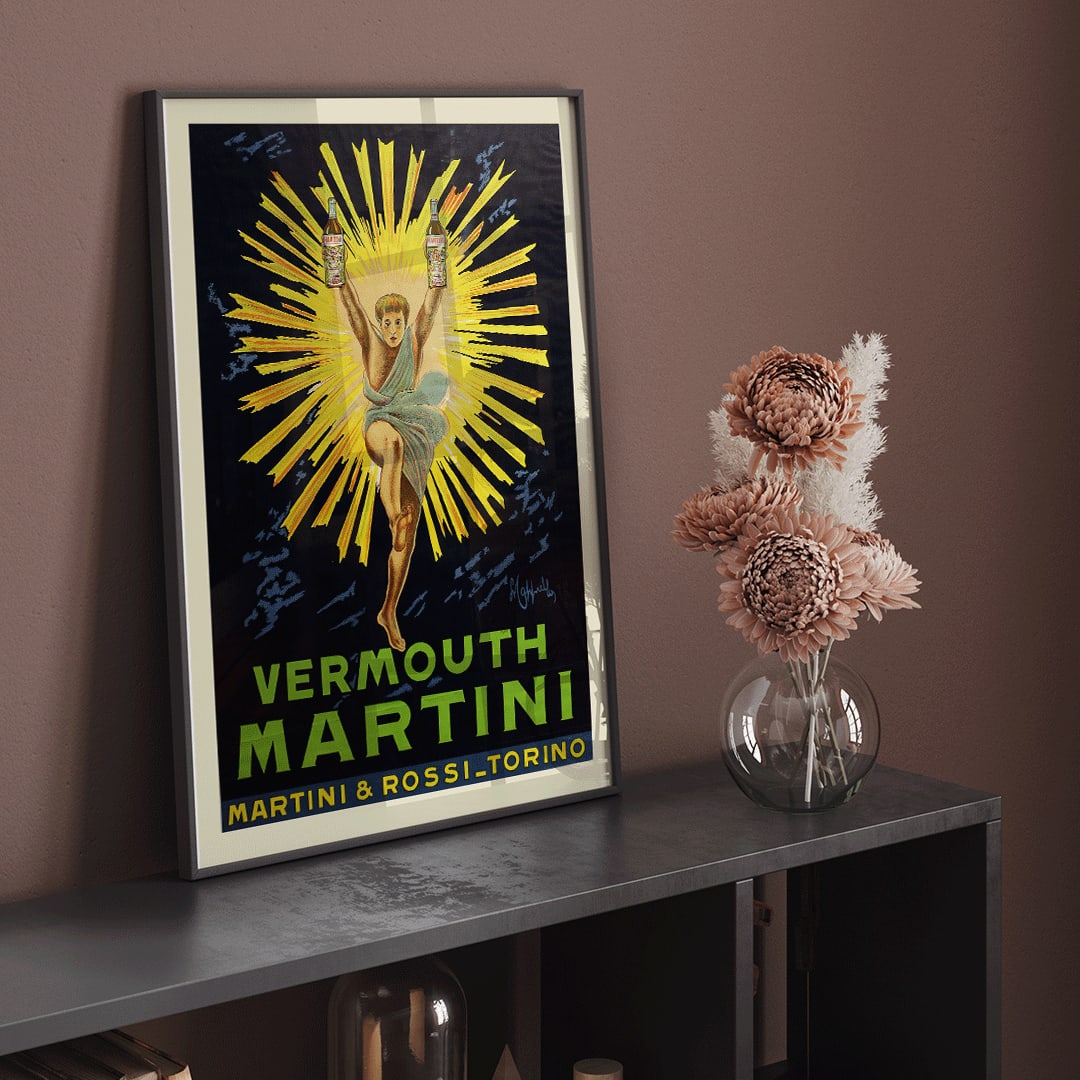 Vintage advertising poster of Vermouth Martini by Leonetto Cappiello featuring a vibrant figure holding bottles with yellow rays burst in the background, framed and displayed in home decor