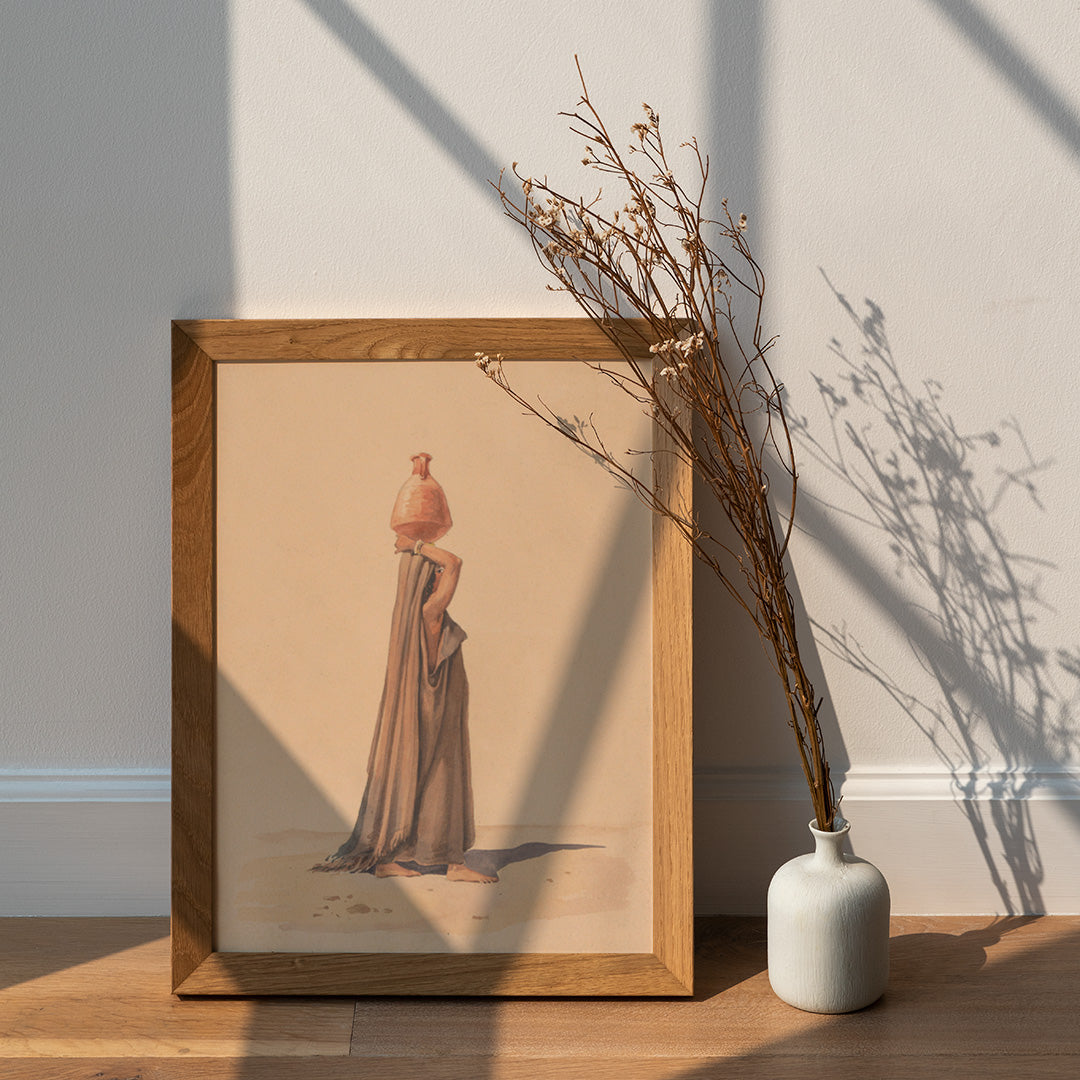 Water carrier by Emile Prisse dAvennes woman in traditional attire carrying water jug on head in desert scene artwork, framed and displayed in home decor